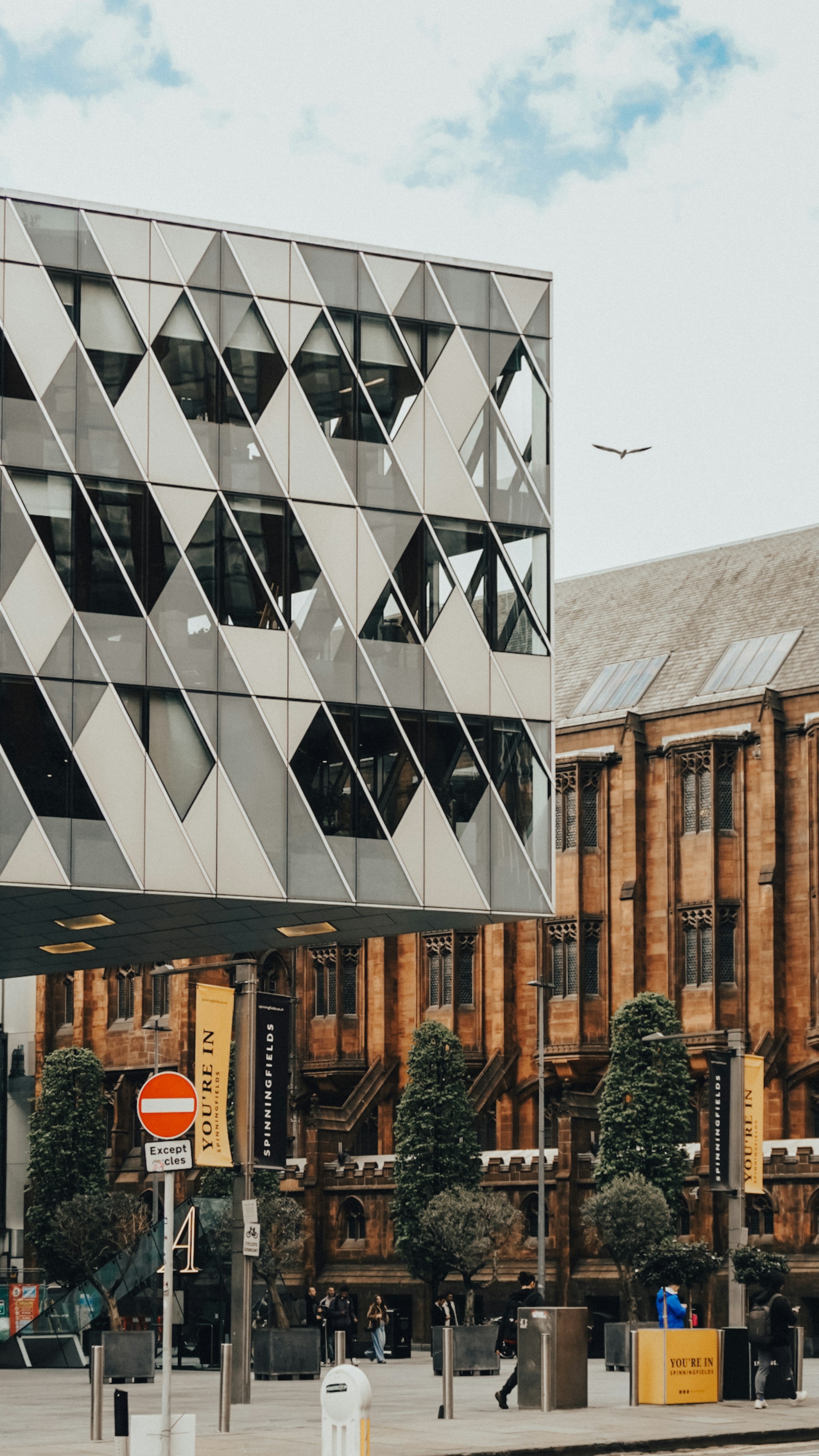Contemporary architecture set against a historic stone building in Manchester